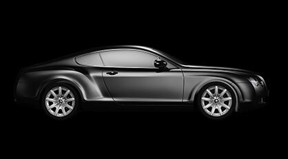Side view of a sleek black sports coupé car on a solid black background.
