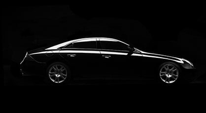 Side view of a sleek black luxury car with illuminated edges, set against a dark background.