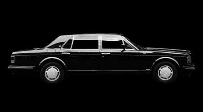 Side profile of a classic black luxury saloon with chrome detailing, isolated on a solid black background.